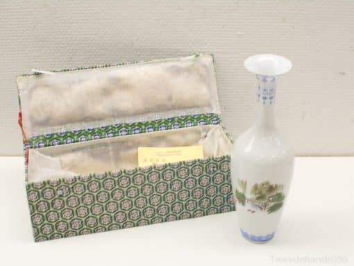 Elegant porcelain vase with floral designs next to a stylish decorative box.