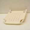Foldable cream shower seat for safety and comfort in small bathrooms.
