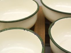 Nostalgic off-white bowls with green rims for a charming farmhouse kitchen aesthetic.