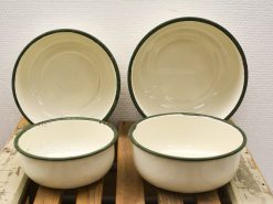 Charming vintage enamel bowls with green rims, ideal for serving and enhancing table aesthetics.