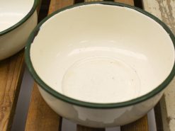 Charming vintage enamel bowl with green trim, perfect for nostalgic kitchen decor and use.