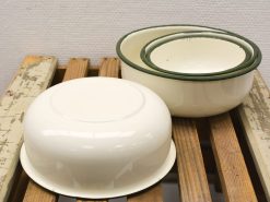 Classic cream enamel bowls with green rims, perfect for vintage kitchen decor and cooking.