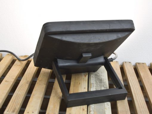 Sleek black monitor on rustic wooden surface, blending modern design with vintage charm.