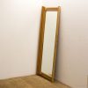 Warm wooden mirror enhances minimalist interiors with vintage charm and serene ambiance.