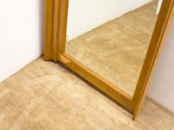 Sleek wooden corner mirror enhancing minimalist decor with warmth and elegance.