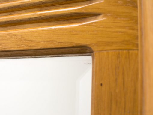 Elegant wooden mirror frame with intricate carvings and a warm, polished finish.