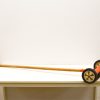 Playful vintage wooden garden tool with colorful wheels, perfect for decor and creativity.