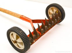 Used wooden lawn aerator with metal blades for efficient grass care and maintenance.