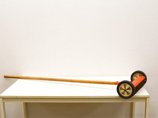 Playful vintage wooden garden tool with colorful wheels, perfect for decor and creativity.