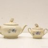 Elegant cream tea set with blue floral patterns, ideal for stylish gatherings and tea rituals.