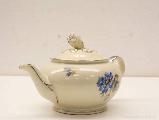 Elegant cream porcelain teapot with blue floral design, perfect for serving tea and decorative display.