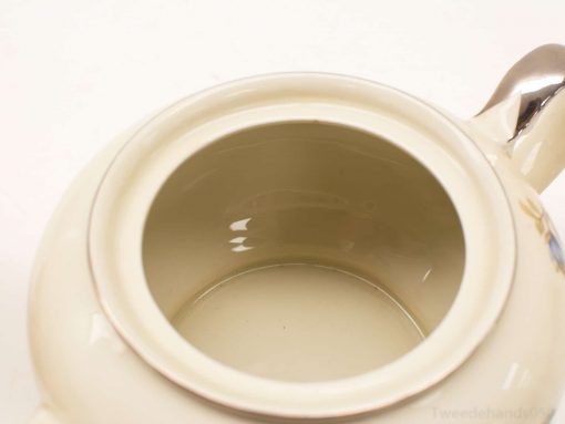 Elegant cream ceramic teapot with a glossy finish, perfect for stylish tea gatherings.