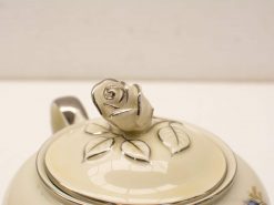 Elegant vintage teapot with rosebud handle and floral design, ideal for tea gatherings.