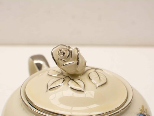 Elegant vintage teapot with rosebud handle and floral design, ideal for tea gatherings.