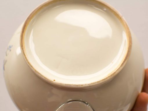 Handcrafted ceramic bowl with glossy white interior and decorative blue patterns, ideal for any setting.