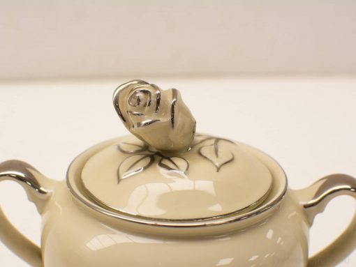 Elegant porcelain container with silver rose knob, perfect for decor and formal occasions.