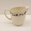 Elegant ceramic pitcher with vintage leaf pattern, perfect for serving or home decor.