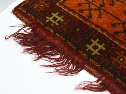 Authentic vintage red and orange geometric rug with intricate patterns and charming fringes.