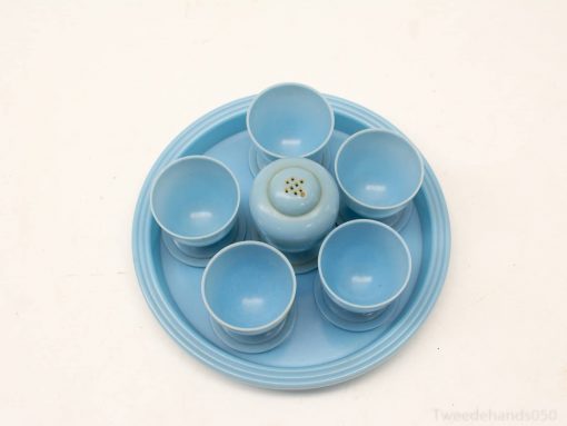 Charming light blue dining set with a tray, shaker, and six elegant cups for entertaining.