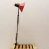 Stylish red conical desk lamp with adjustable black arm, perfect for modern workspaces.