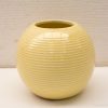 Modern yellow ceramic vase with textured ridges, perfect for decorative floral arrangements.