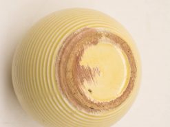 Handcrafted yellow ceramic bowl with textured ridges, perfect for decor and everyday use.