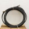 Heavy-duty coiled black hose with brass connector, perfect for irrigation and pressure washing applications.