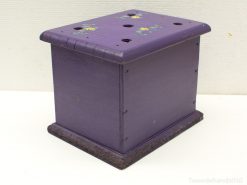 Vibrant purple wooden box with floral designs and ventilation holes for plants or decorative storage.