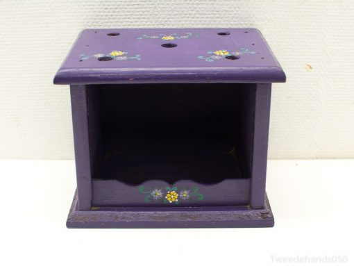 Charming purple wooden storage box with floral motifs and circular openings for organization.