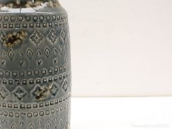 Elegant vintage ceramic vase with geometric patterns in soothing blue tones.