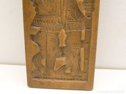 Intricate wooden carving of a virtuous figure with a dog, showcasing rich cultural heritage.