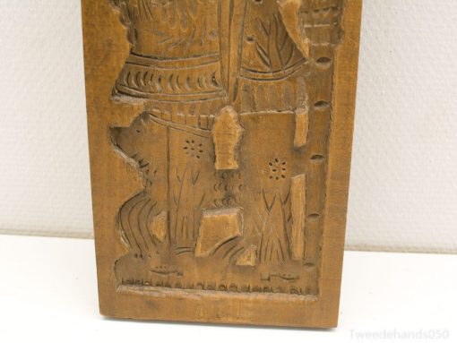 Intricate wooden carving of a virtuous figure with a dog, showcasing rich cultural heritage.