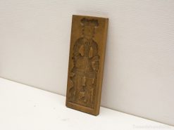 Antique wooden print block featuring detailed traditional figurine with cultural significance.