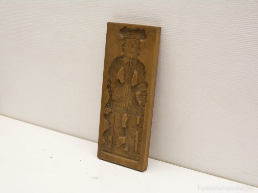 Antique wooden print block featuring detailed traditional figurine with cultural significance.