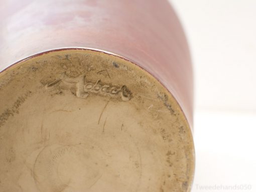 Handmade ceramic vase with Mebach mark, showcasing rustic red tones and unique craftsmanship.