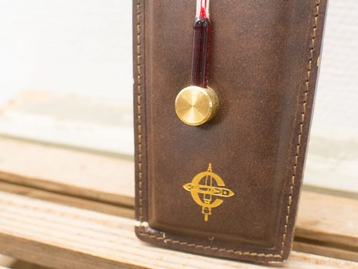 Elegant vintage leather accessory with gold barometer and red liquid for technical use.