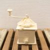 Charming vintage coffee grinder with lace decoration, perfect for lovers of rustic decor.