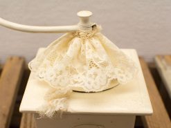 Charming vintage pepper mill with lace cover adds elegance to your kitchen decor.