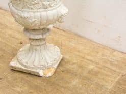 Weathered white garden urn with intricate details and classic design accents for outdoor elegance.