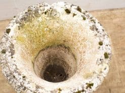 Weathered stone planter with moss, showcasing rustic charm for garden decor.
