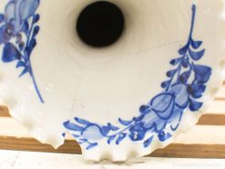 Antique porcelain vase with intricate blue floral designs and scalloped edges, showcasing exquisite craftsmanship.