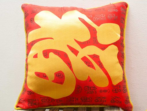 Vibrant red and gold decorative cushion with elegant embroidery, perfect for adding cultural charm.