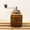 Vintage wooden coffee grinder with metal mechanism, perfect for nostalgic coffee enthusiasts.