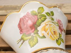 Elegant antique porcelain vase with vibrant rose motif and gold trim, perfect for stylish decor.