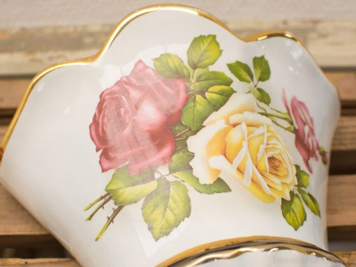 Elegant antique porcelain vase with vibrant rose motif and gold trim, perfect for stylish decor.