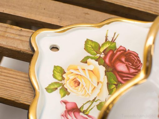 Ornate porcelain plate featuring a yellow rose design, ideal for decor or special occasions.