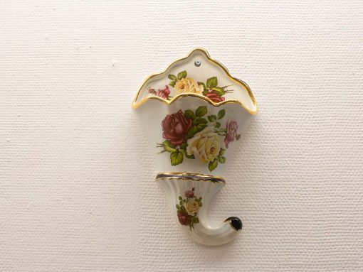 Elegant porcelain wall pocket with rose design and gold trim for stylish floral display.
