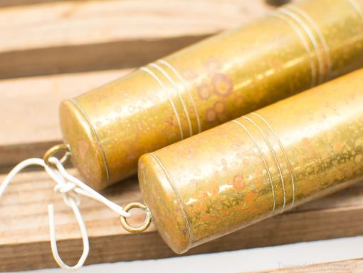 Vintage brass cylinders connected by string, showcasing unique patina and artistic craftsmanship.