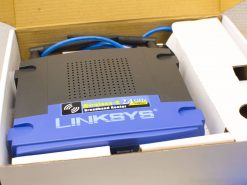 Linksys Wireless-B broadband router, vintage design, includes two Ethernet cables for reliable connectivity.