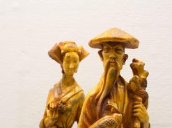 Elegant carved figurines of a wise man and graceful woman, showcasing exquisite craftsmanship and cultural heritage.